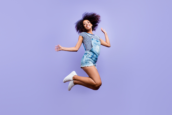 Bottom view portrait of crazy positive girl in jeans outfit jumping in air enjoying daydream having weekend vacation holiday isolated on violent background. Luck success concept