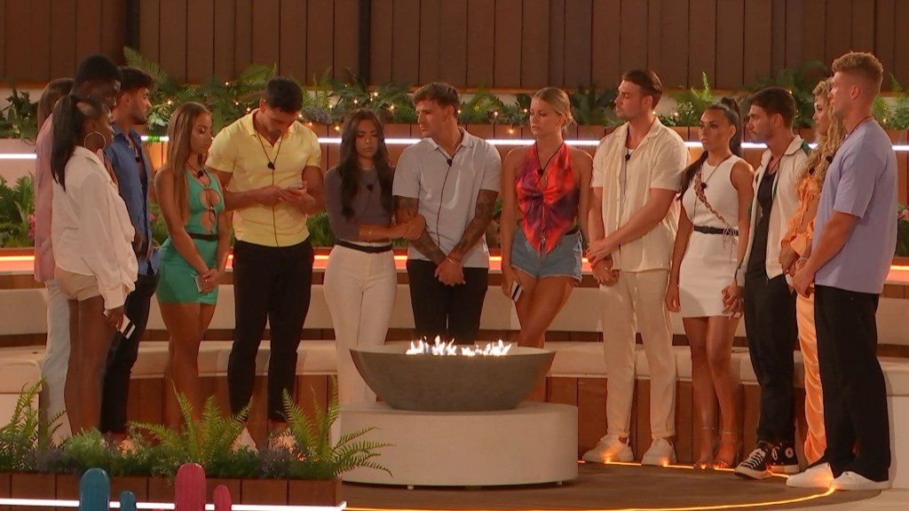 Love Island contestants standing around the firepit