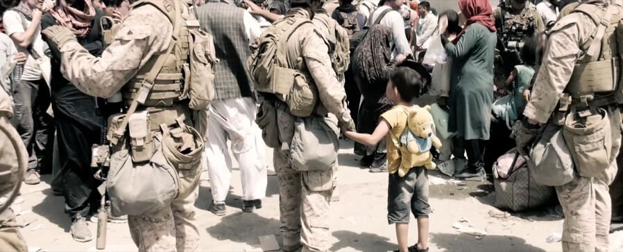 Pictured: Soldier holding child?s hand wide shot