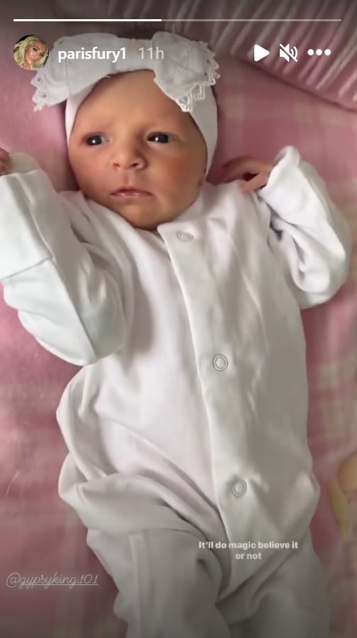 Paris Fury's baby Athena in a white baby grow on a pink blanket