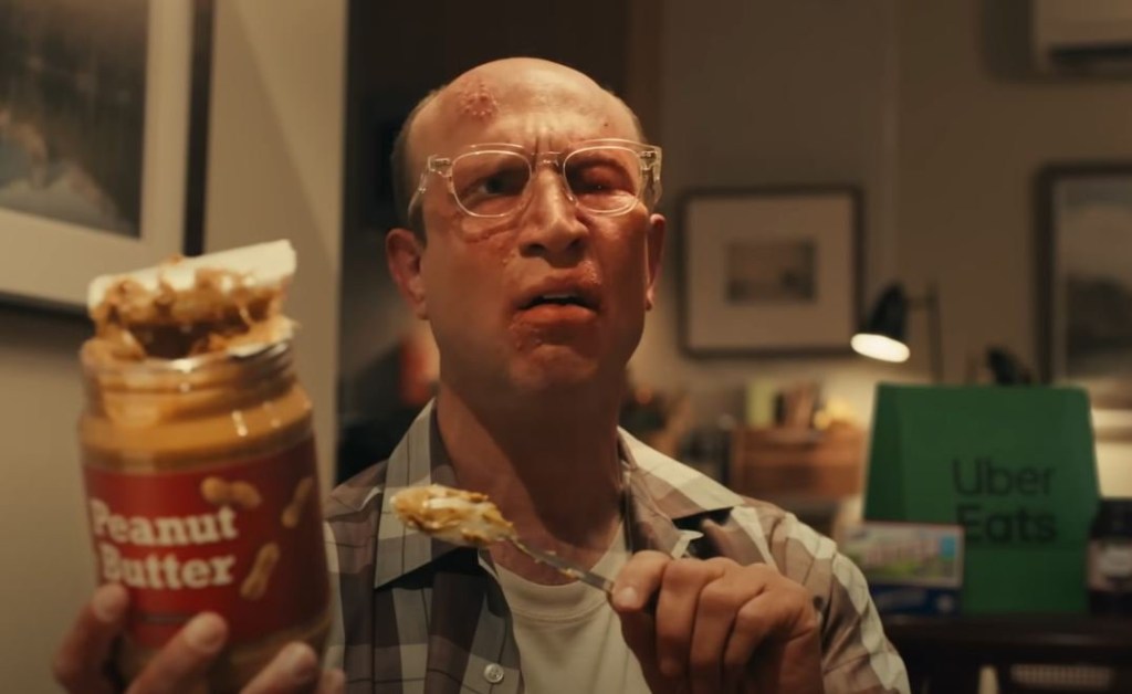 A man eats a jar of peanut butter in a Super Bowl Uber Eats advert