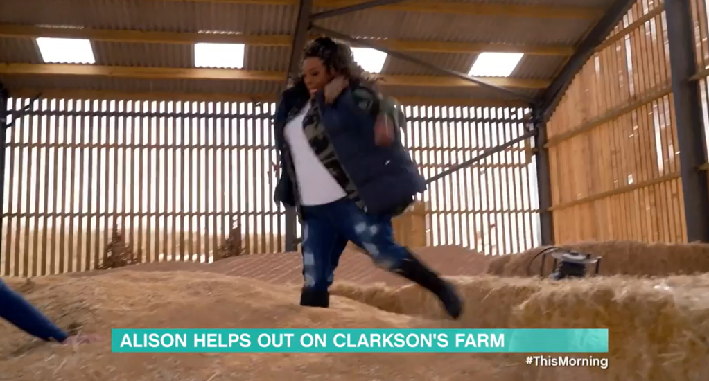 Alison Hammond on top of a pile of hay.