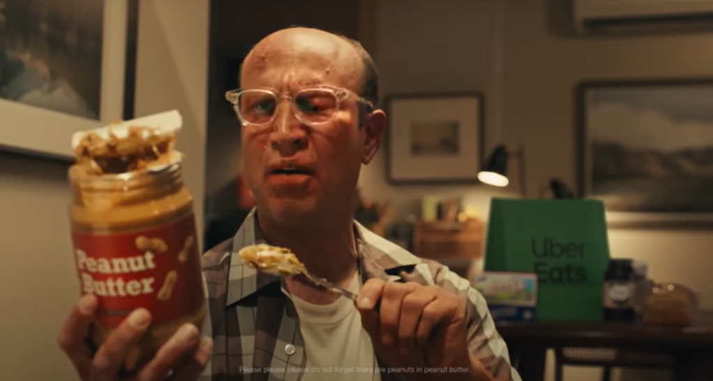 A man eats a jar of peanut butter in a Super Bowl Uber Eats advert
