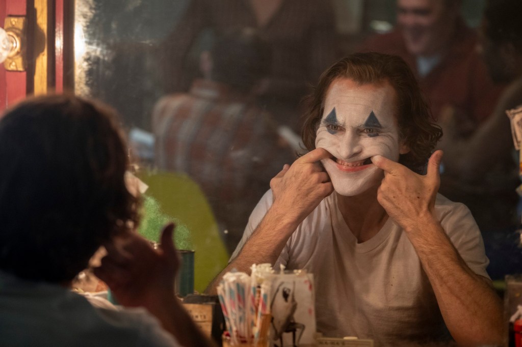 This image released by Warner Bros. Pictures shows Joaquin Phoenix in clown make-up in a scene from 
