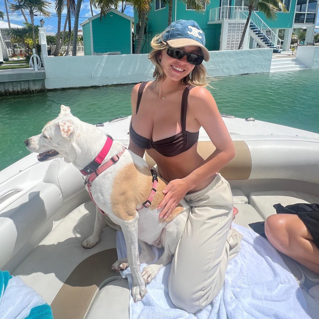Sydney Sweeney holding a dog on a boat