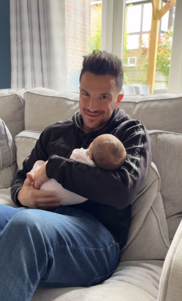 Peter Andre holding his newborn daughter